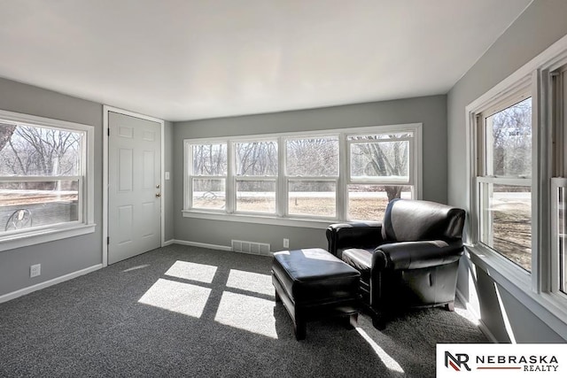 sitting room with visible vents, dark carpet, and baseboards