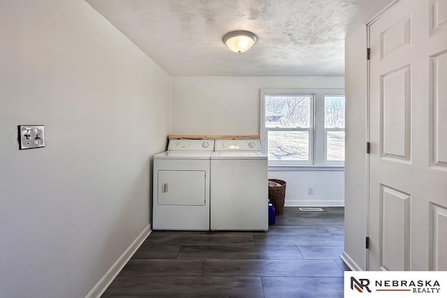 washroom featuring dark wood-style floors, laundry area, washing machine and dryer, and baseboards