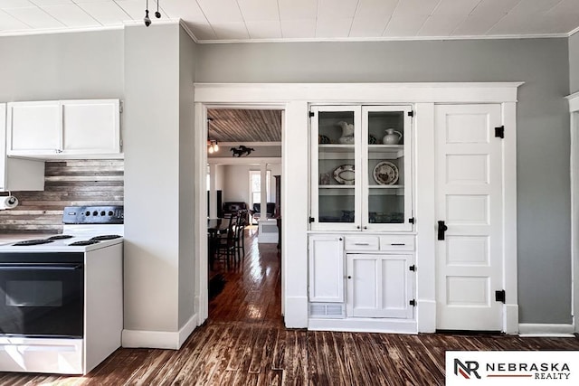 kitchen with dark wood finished floors, electric range oven, white cabinetry, glass insert cabinets, and baseboards