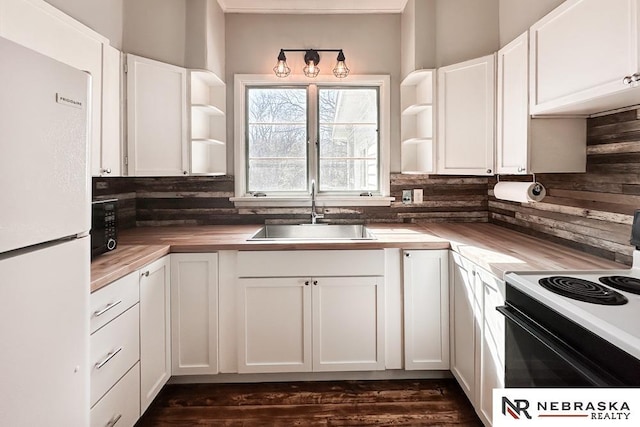 kitchen featuring open shelves, a sink, black appliances, white cabinetry, and butcher block counters