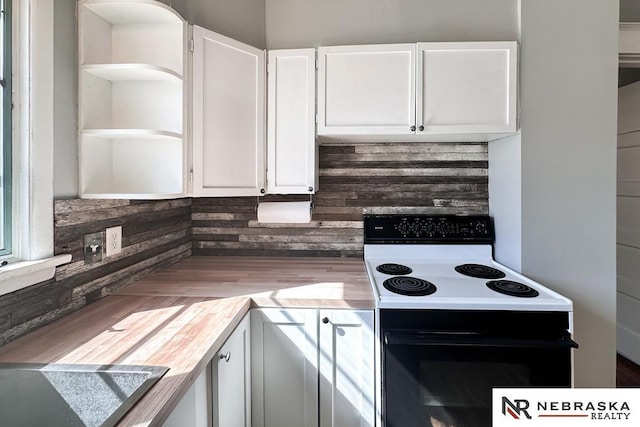 kitchen featuring open shelves, white cabinets, light countertops, and electric stove