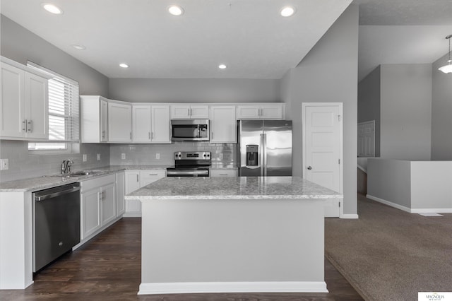 kitchen with a sink, appliances with stainless steel finishes, white cabinets, and a center island