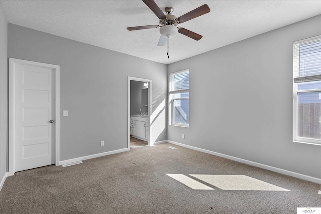 unfurnished bedroom featuring visible vents, multiple windows, baseboards, and carpet floors