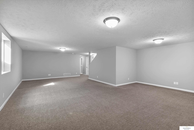 finished basement featuring visible vents, baseboards, and carpet