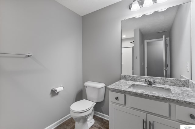 bathroom with visible vents, toilet, vanity, and baseboards