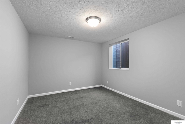 spare room with visible vents, baseboards, a textured ceiling, and dark carpet