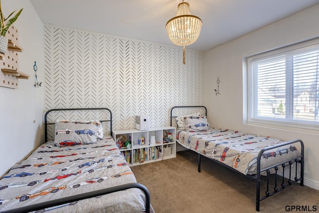 carpeted bedroom featuring a notable chandelier and an accent wall