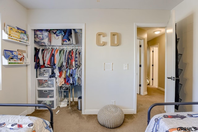 carpeted bedroom with a closet and baseboards