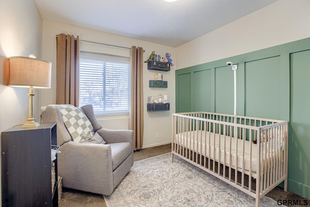 bedroom featuring baseboards, light carpet, and a crib