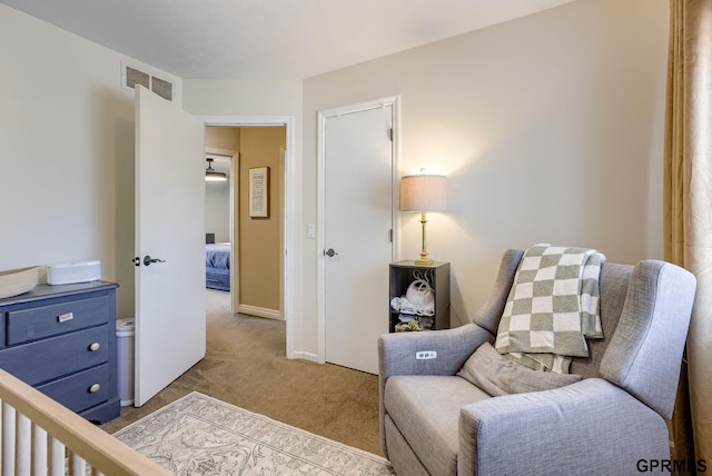 sitting room with carpet flooring, baseboards, and visible vents