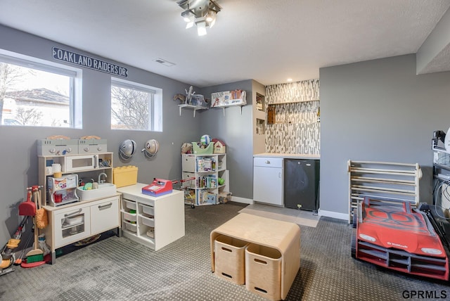 recreation room with visible vents and baseboards