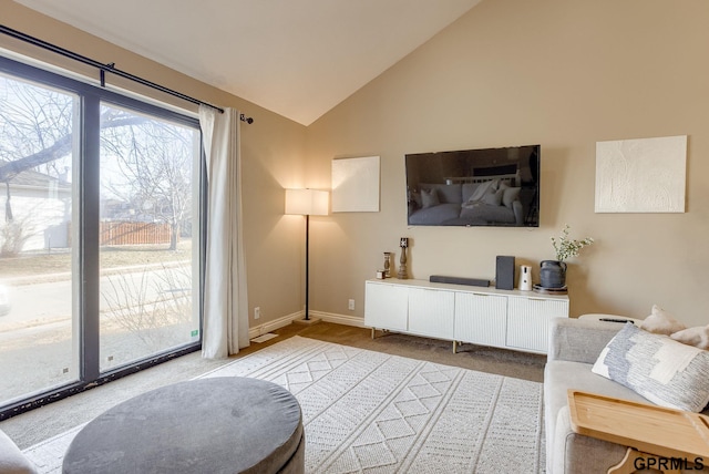 living room featuring baseboards, lofted ceiling, and carpet