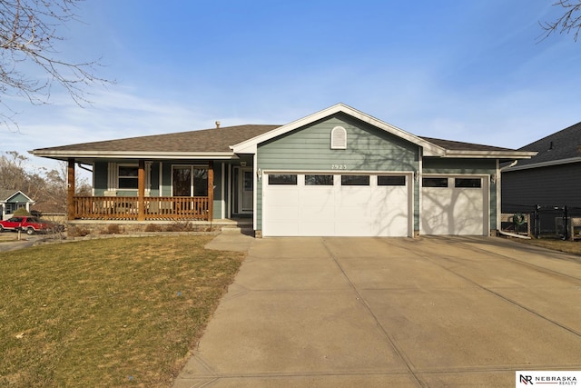 ranch-style home featuring covered porch, concrete driveway, a front yard, a shingled roof, and a garage