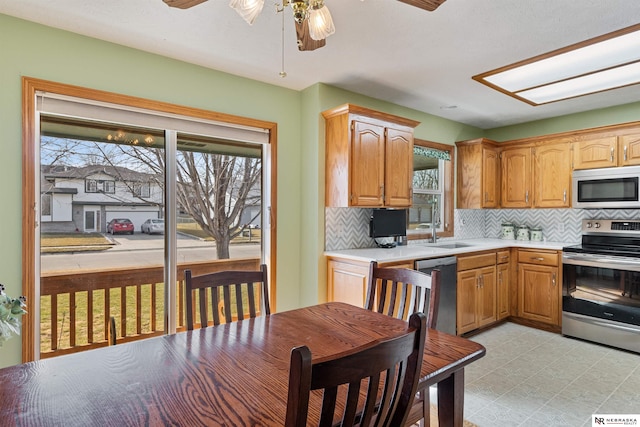 kitchen featuring a sink, a healthy amount of sunlight, a ceiling fan, and stainless steel appliances