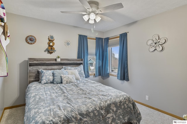 bedroom with a ceiling fan, baseboards, and carpet floors