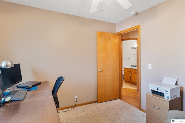 office area with ceiling fan, baseboards, and carpet