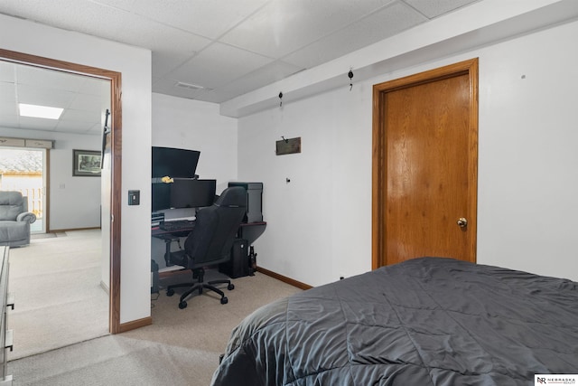 bedroom with a drop ceiling, light colored carpet, baseboards, and visible vents