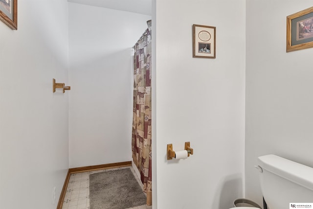 full bathroom with tile patterned floors, toilet, and baseboards