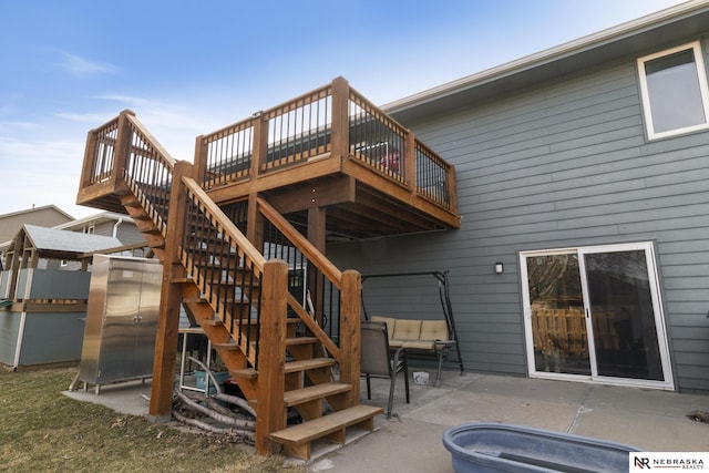 rear view of house with stairs, a deck, and a patio area