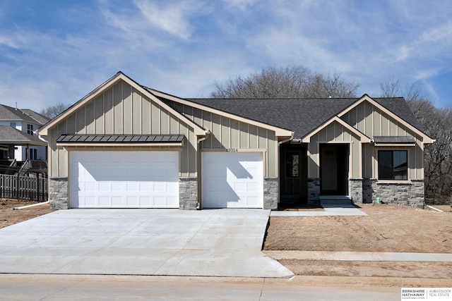 view of front of property with a standing seam roof, stone siding, board and batten siding, and a garage