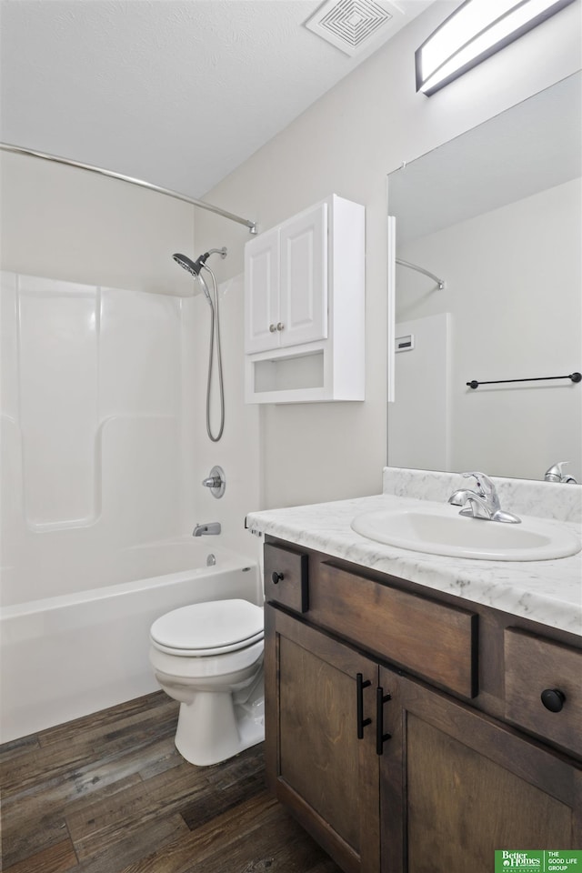 full bath with visible vents, toilet, shower / tub combination, wood finished floors, and vanity