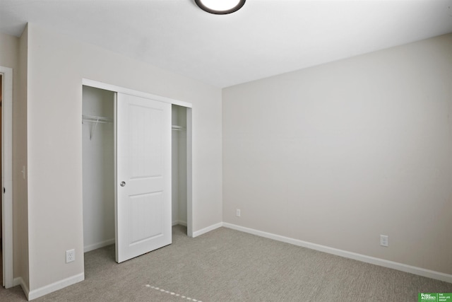 unfurnished bedroom featuring carpet flooring, baseboards, and a closet