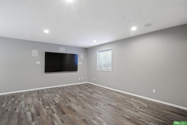 unfurnished living room with recessed lighting, wood finished floors, and baseboards