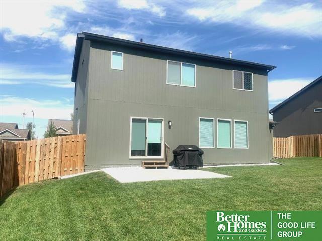 rear view of house featuring a patio, a yard, and a fenced backyard