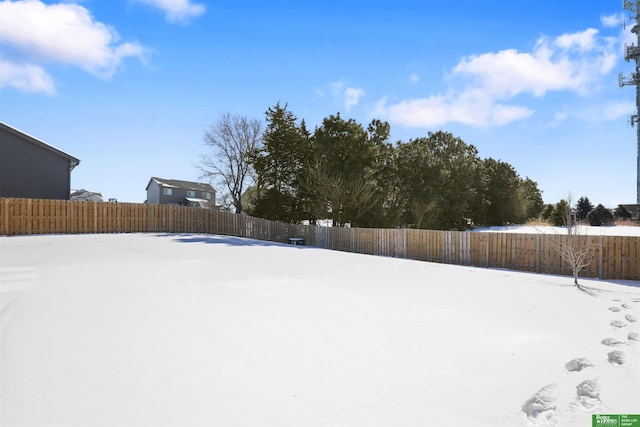 yard covered in snow featuring a fenced backyard