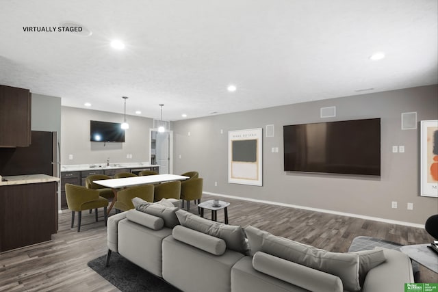 living area featuring light wood finished floors, recessed lighting, and baseboards