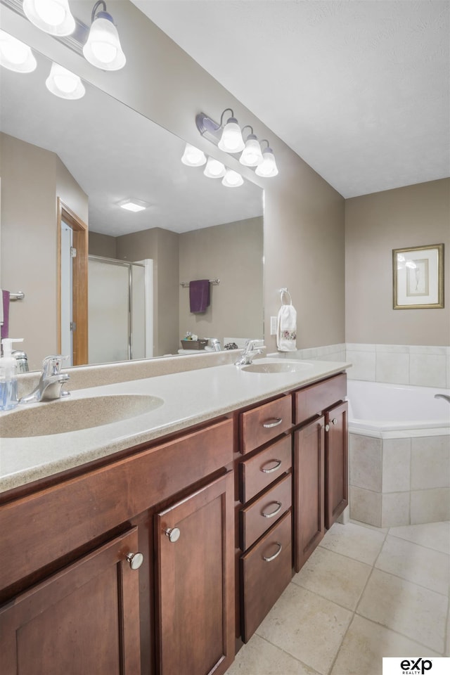 full bathroom featuring tile patterned flooring, a stall shower, a garden tub, and a sink