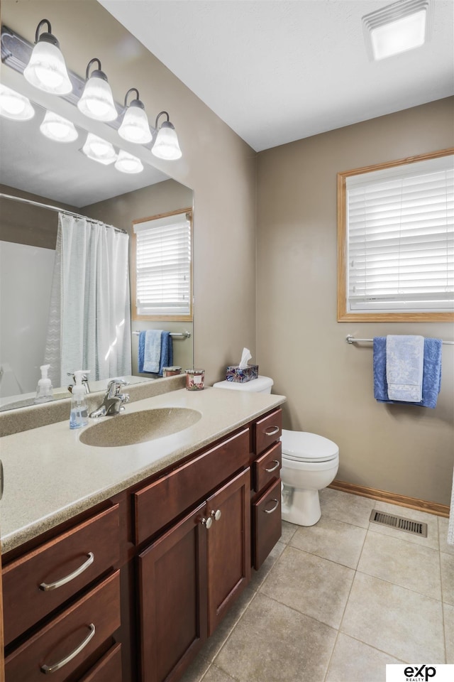 bathroom with vanity, a shower with shower curtain, visible vents, tile patterned flooring, and toilet