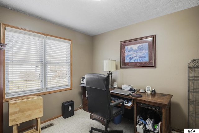 home office with baseboards, carpet floors, a textured ceiling, and visible vents