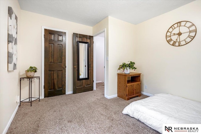 bedroom featuring carpet flooring, a textured ceiling, and baseboards