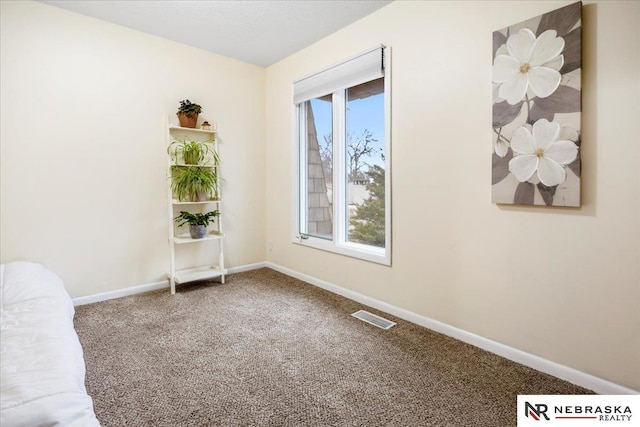 empty room with visible vents, carpet floors, and baseboards