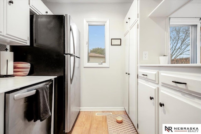 kitchen with white cabinetry, light countertops, visible vents, and stainless steel appliances