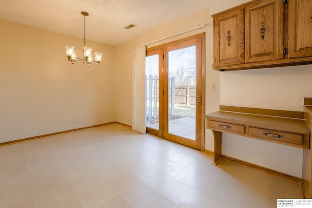 doorway featuring visible vents, baseboards, a notable chandelier, and a textured ceiling