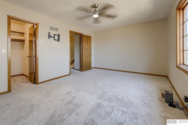 unfurnished bedroom with carpet, baseboards, visible vents, and a textured ceiling