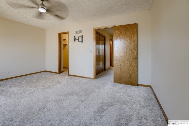 unfurnished room with visible vents, baseboards, a textured ceiling, and ceiling fan