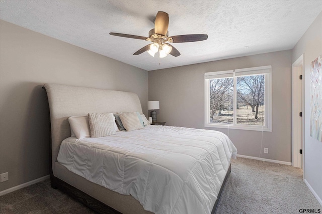 bedroom featuring ceiling fan, a textured ceiling, baseboards, and carpet floors