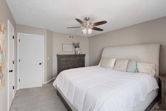 carpeted bedroom with visible vents, baseboards, and a ceiling fan