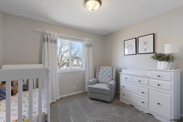 carpeted bedroom featuring baseboards and a nursery area