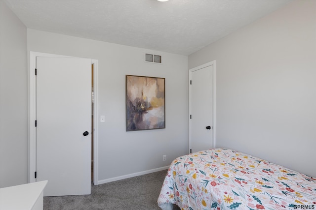 carpeted bedroom with visible vents, a textured ceiling, and baseboards