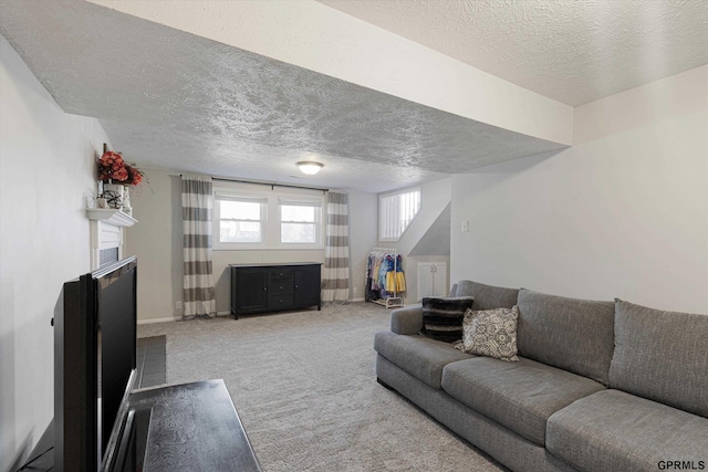 carpeted living room with baseboards, a textured ceiling, and a fireplace