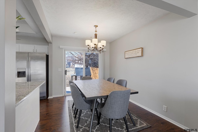 dining area featuring baseboards, a textured ceiling, a chandelier, and dark wood finished floors