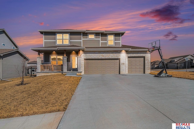 view of front of property with an attached garage, a porch, a yard, stone siding, and driveway