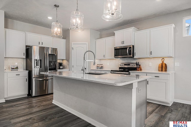 kitchen with a kitchen island with sink, a sink, white cabinetry, appliances with stainless steel finishes, and dark wood-style flooring