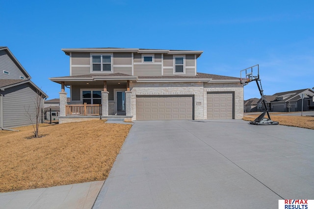 prairie-style home with driveway, covered porch, roof with shingles, an attached garage, and a front yard