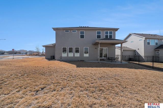 back of property with a patio, a lawn, and fence