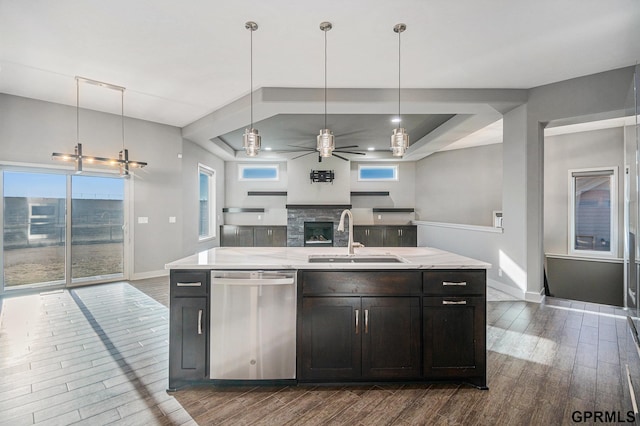 kitchen featuring dark wood finished floors, a sink, stainless steel dishwasher, ceiling fan with notable chandelier, and open floor plan